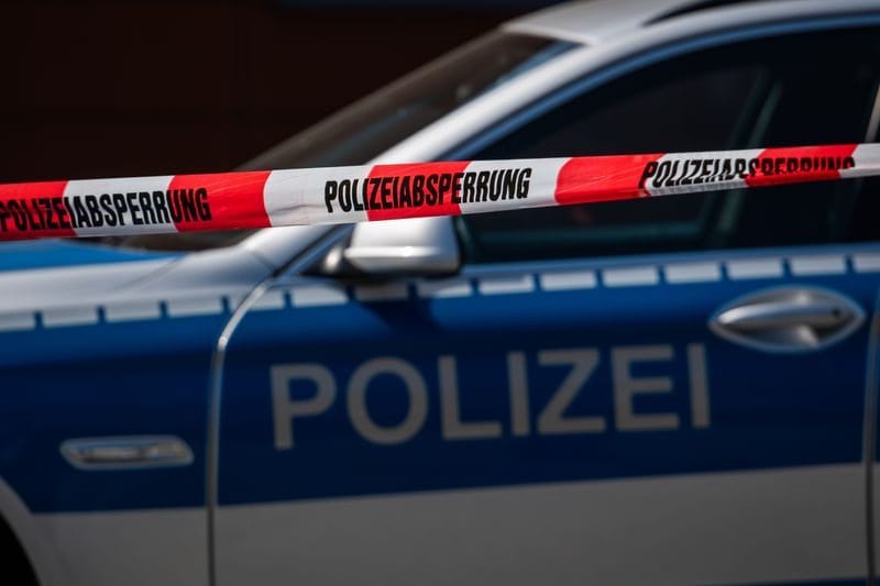 Ein Polizeiauto steht hinter einem Absperrband der Polizei (Symbolbild): Der Brand sorgt für entsetzte Reaktionen von Politikern.