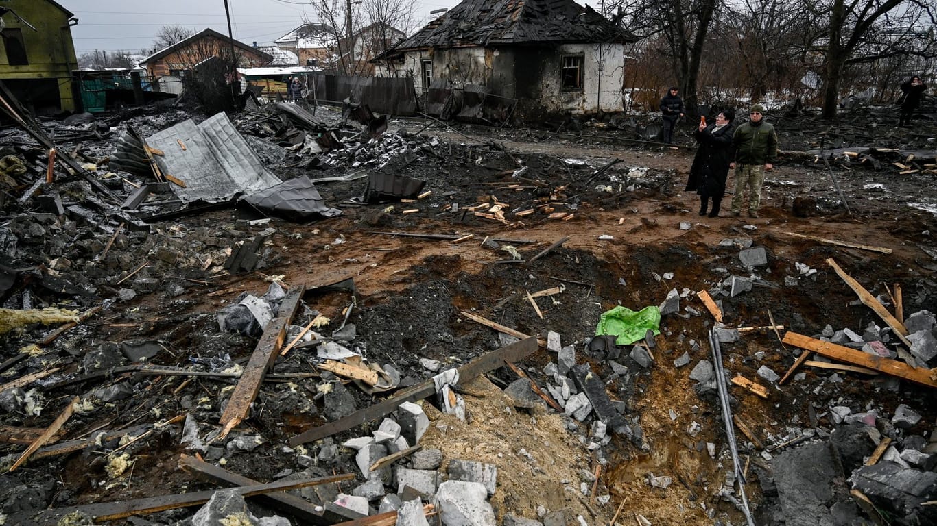 Menschen inspizieren ein zerstörtes Haus nach einem russischen Raketenangriff.