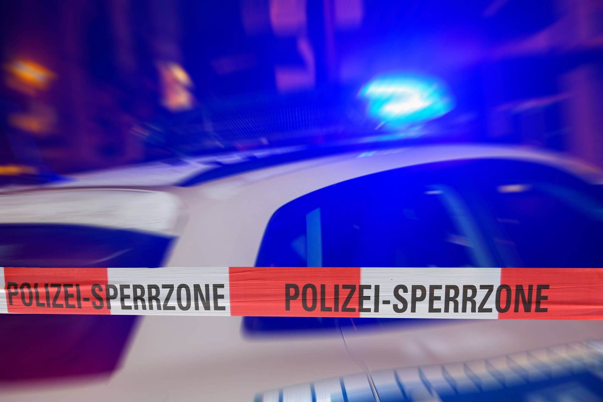 Polizeiabsperrung bei Nacht mit Polizeiauto dahinter (Symbolbild): Eine Fahndung nach den Tätern blieb erfolglos.