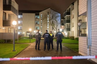 Polizisten stehen im Wohnkomplex in Bonn-Tannenbusch: Hier wurde am Nachmittag der Tote entdeckt.