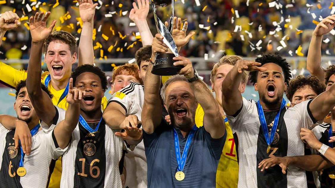 Am Ziel: U17-Nationaltrainer Christian Wück (M.) mit dem WM-Pokal inmitten seiner Spieler.