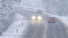 Autos auf einer verschneiten Landstraße (Symbolbild): In einigen Regionen warnt der Wetterdienst davor, Auto zu fahren.