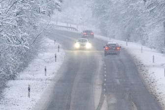Autos auf einer verschneiten Landstraße (Symbolbild): In einigen Regionen warnt der Wetterdienst davor, Auto zu fahren.