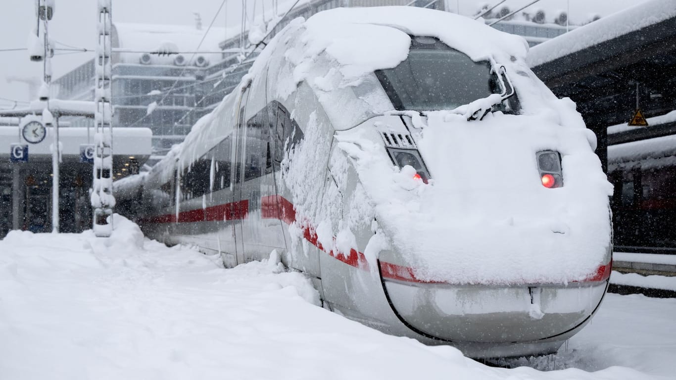 Ein ICE der Deutschen Bahn (DB) steht auf einem verschneiten Gleis am Hauptbahnhof. Der Zugverkehr von und zum Hauptbahnhof wurde vorübergehend eingestellt.