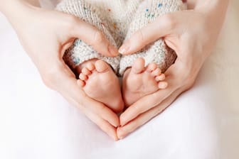 Eine Mutter hält die Füße ihres Babys fest: Der Namensforscher Knud Bielefeld veröffentlicht jedes Jahr eine Liste mit den beliebtesten Vornamen für Neugeborene.