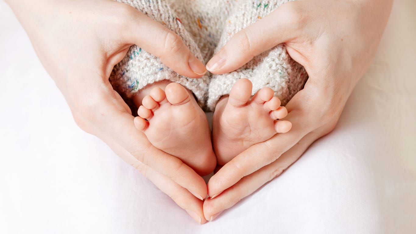 Eine Mutter hält die Füße ihres Babys fest: Der Namensforscher Knud Bielefeld veröffentlicht jedes Jahr eine Liste mit den beliebtesten Vornamen für Neugeborene.
