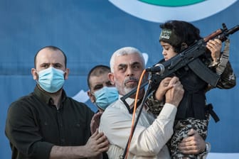Jahja Sinwar hält ein Kind und ein Sturmgewehr hoch (Archivbild): Der Führer der Hamas im Gazastreifen will keine Verhandlungen mit Israel.