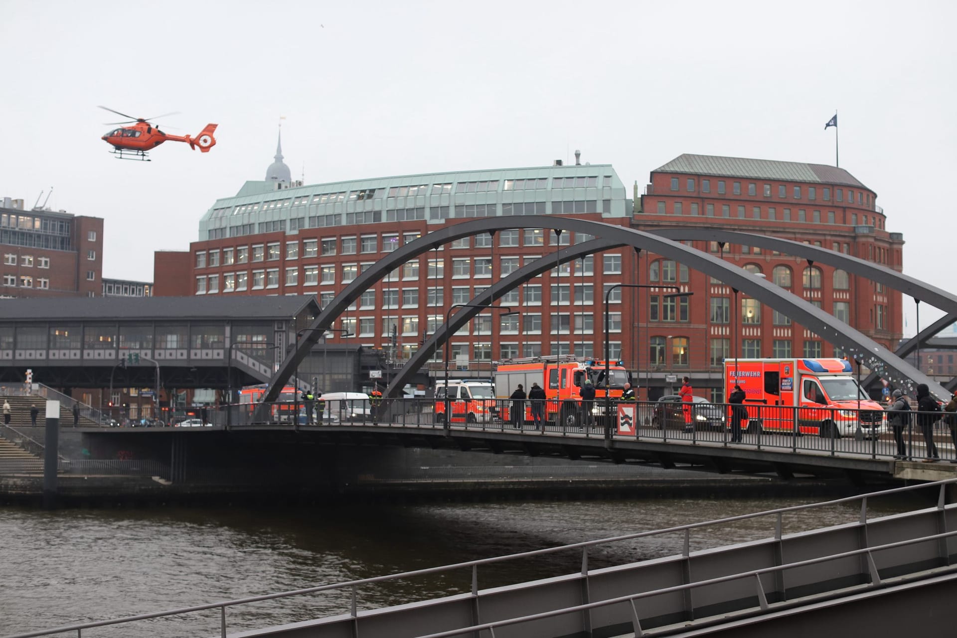 Ein Rettungshubschrauber steht über der Niederbaumbrücke: Am Baumwall hat eine Frau eine leblose Person gesehen.