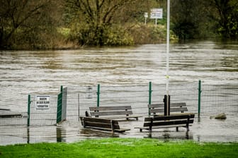Sitzbänke des Freibads Steele stehen im Hochwasser an der Ruhr (Archivbild): Am Samstag hat die Stadt Essen vor Überflutungen gewarnt.