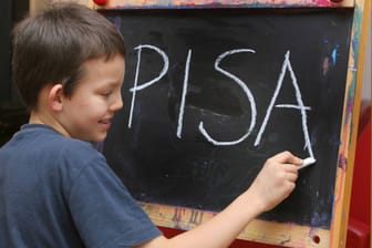 Ein Schulkind schreibt "PISA" auf eine Tafel (Symbolbild): Schüler schneiden in der Studie so schlecht ab wie nie zuvor.