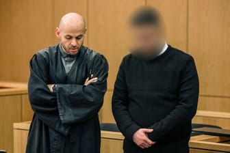 Aachen: Einer der Angeklagten (r) steht neben seinem Anwalt im Gerichtssaal.