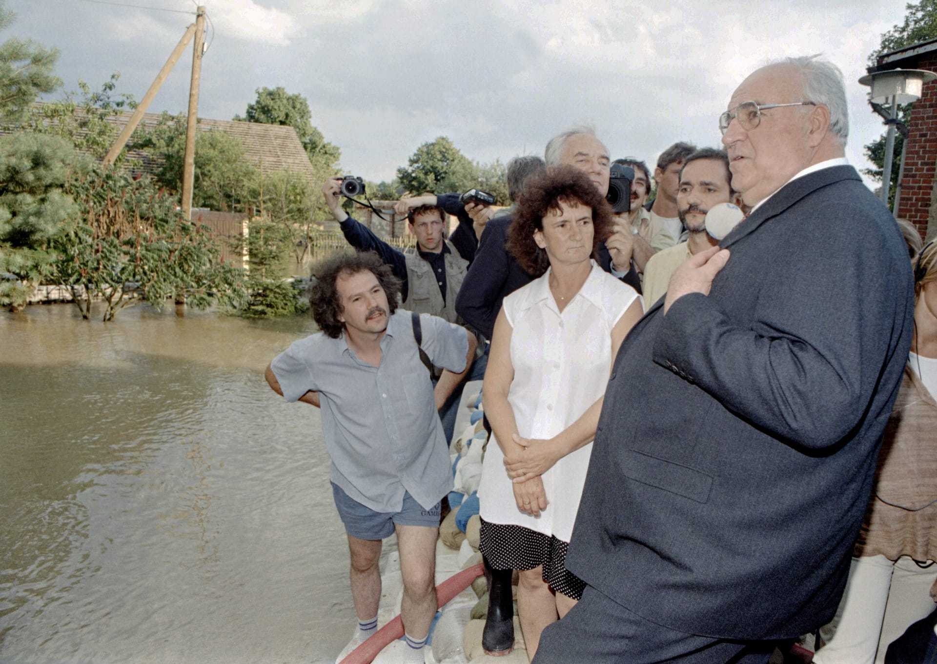 Der damalige Bundeskanzler Helmut Kohl steht auf einem Deich aus Sandsäcken im überfluteten Dorf Ratzdorf. Der Ort in Brandenburg nahe der polnischen Grenze wurde 1997 durch das Oderhochwasser teilweise überflutet.