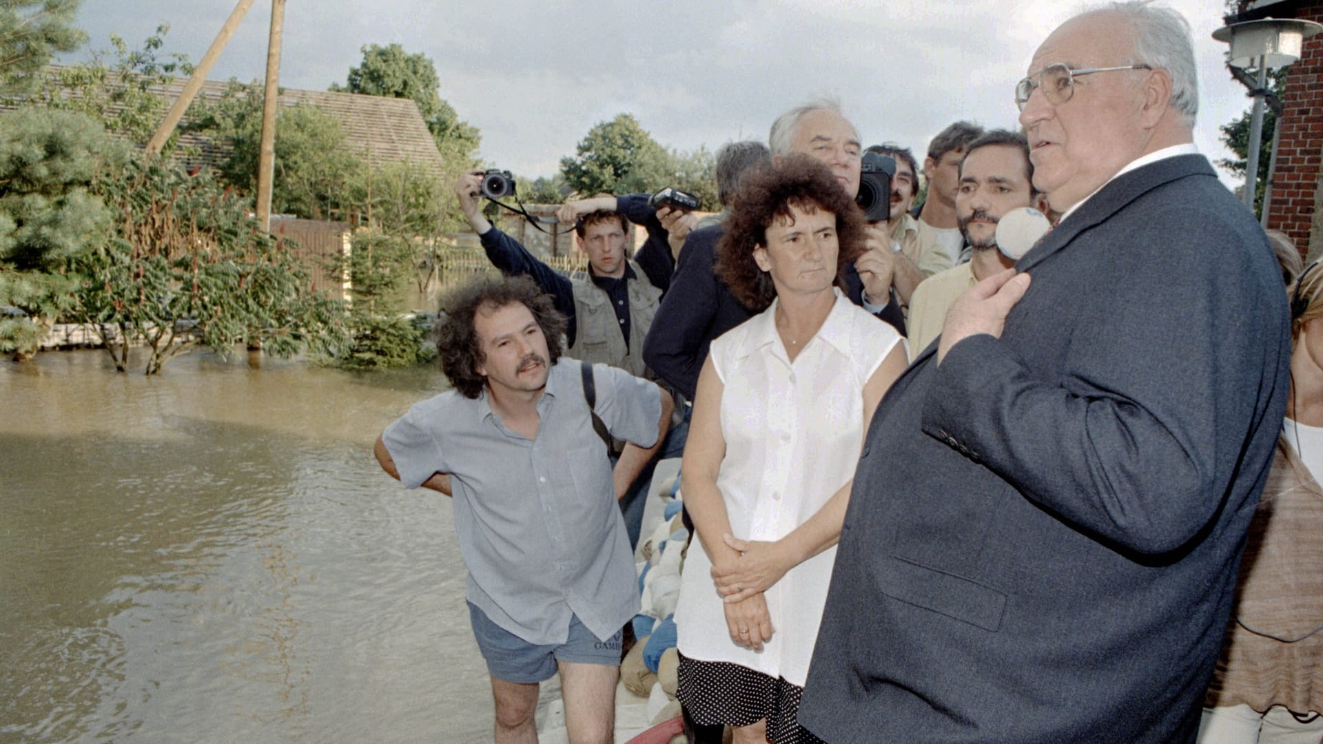 Der damalige Bundeskanzler Helmut Kohl steht auf einem Deich aus Sandsäcken im überfluteten Dorf Ratzdorf. Der Ort in Brandenburg nahe der polnischen Grenze wurde 1997 durch das Oderhochwasser teilweise überflutet.