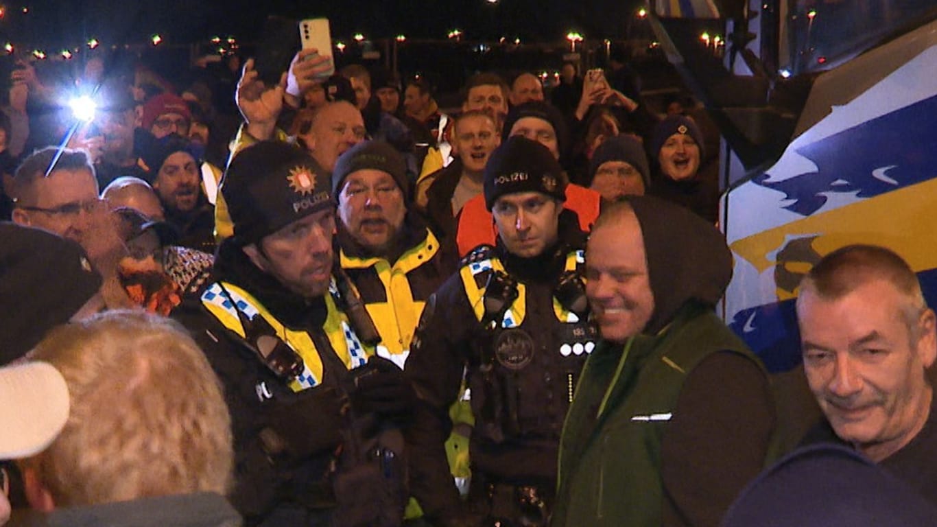 Polizisten diskutieren mit Landwirten auf einer Kreuzung mit Zufahrt zum Hafen im Süden von Hamburg. Die Bauernproteste hielten auch in der Nacht zum Dienstag an.