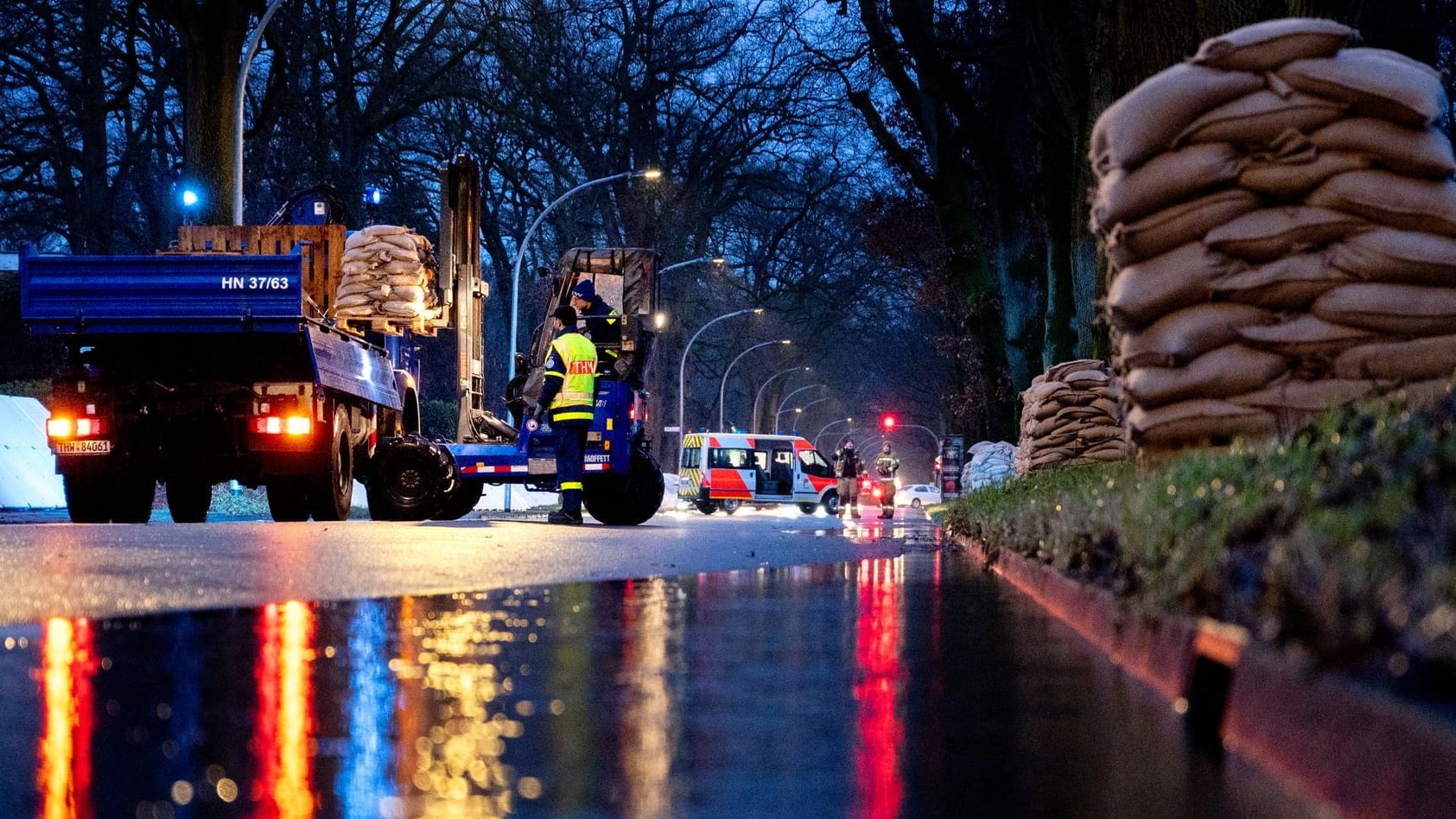 Hochwasser in Oldenburg: Einsatzkräfte laden bei Regen zahlreiche Sandsäcke an der Sandkruger Straße im Stadtteil Bümmerstede ab.