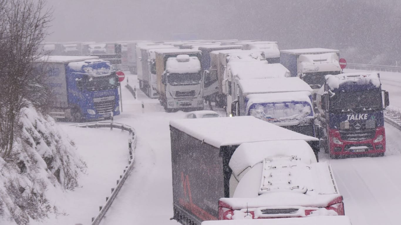 Lastwagen stecken im Stau auf der schneebedeckten Autobahn 5 bei Alsfeld fest.