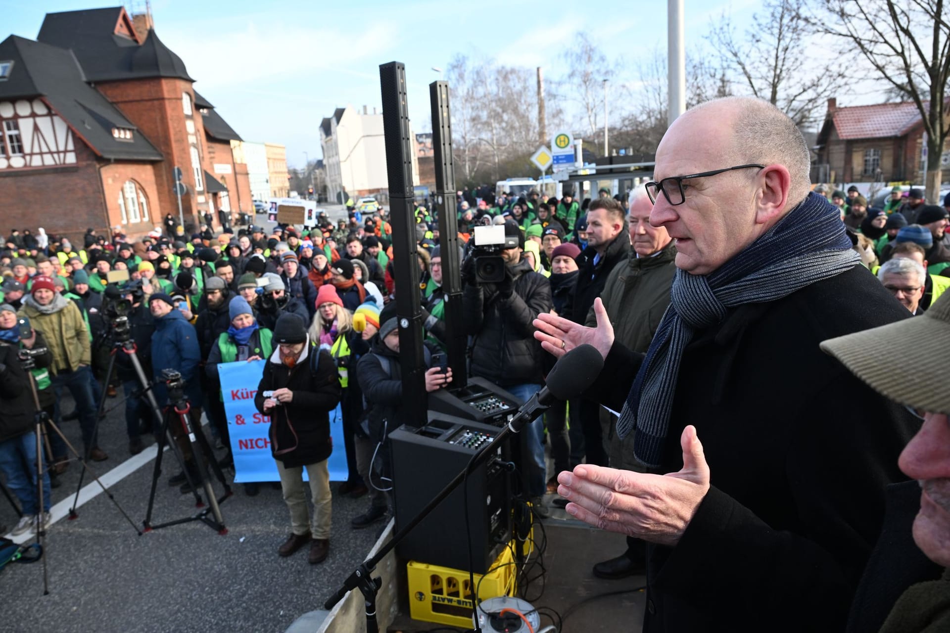 Brandenburgs Ministerpräsident Dietmar Woidke (SPD) spricht zu protestierenden Bauern in Cottbus: Einige Meter weiter eröffnete Bundeskanzler Olaf Scholz heute ein neues ICE-Werk.