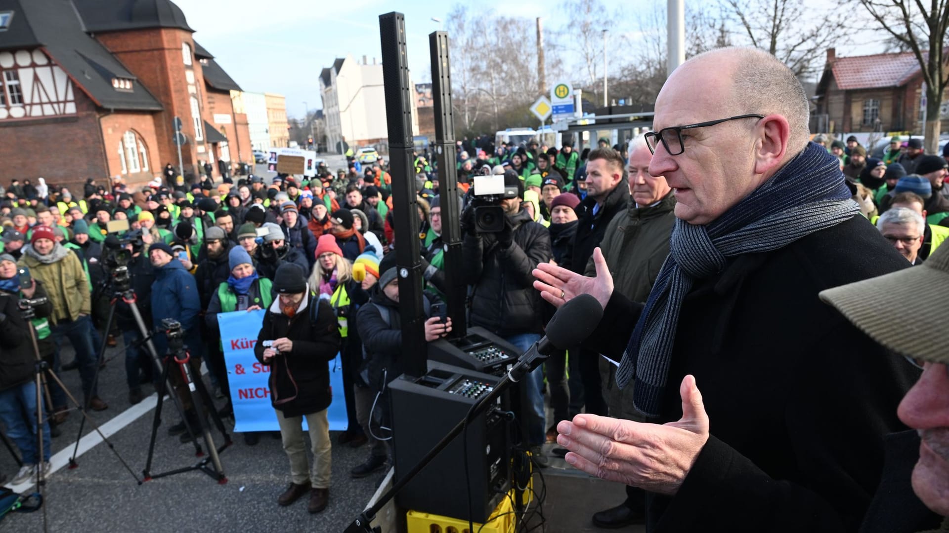 Brandenburgs Ministerpräsident Dietmar Woidke (SPD) spricht zu protestierenden Bauern in Cottbus: Einige Meter weiter eröffnete Bundeskanzler Olaf Scholz heute ein neues ICE-Werk.