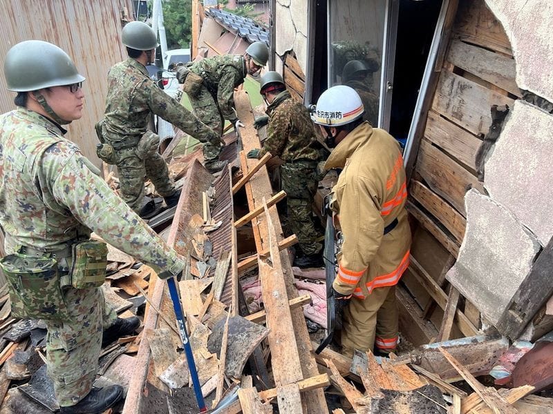 Einheiten der japanischen Selbstverteidigungsstreitkräfte arbeiten sich durch die Trümmer eines zerstörten Wohnhauses in Wajima.