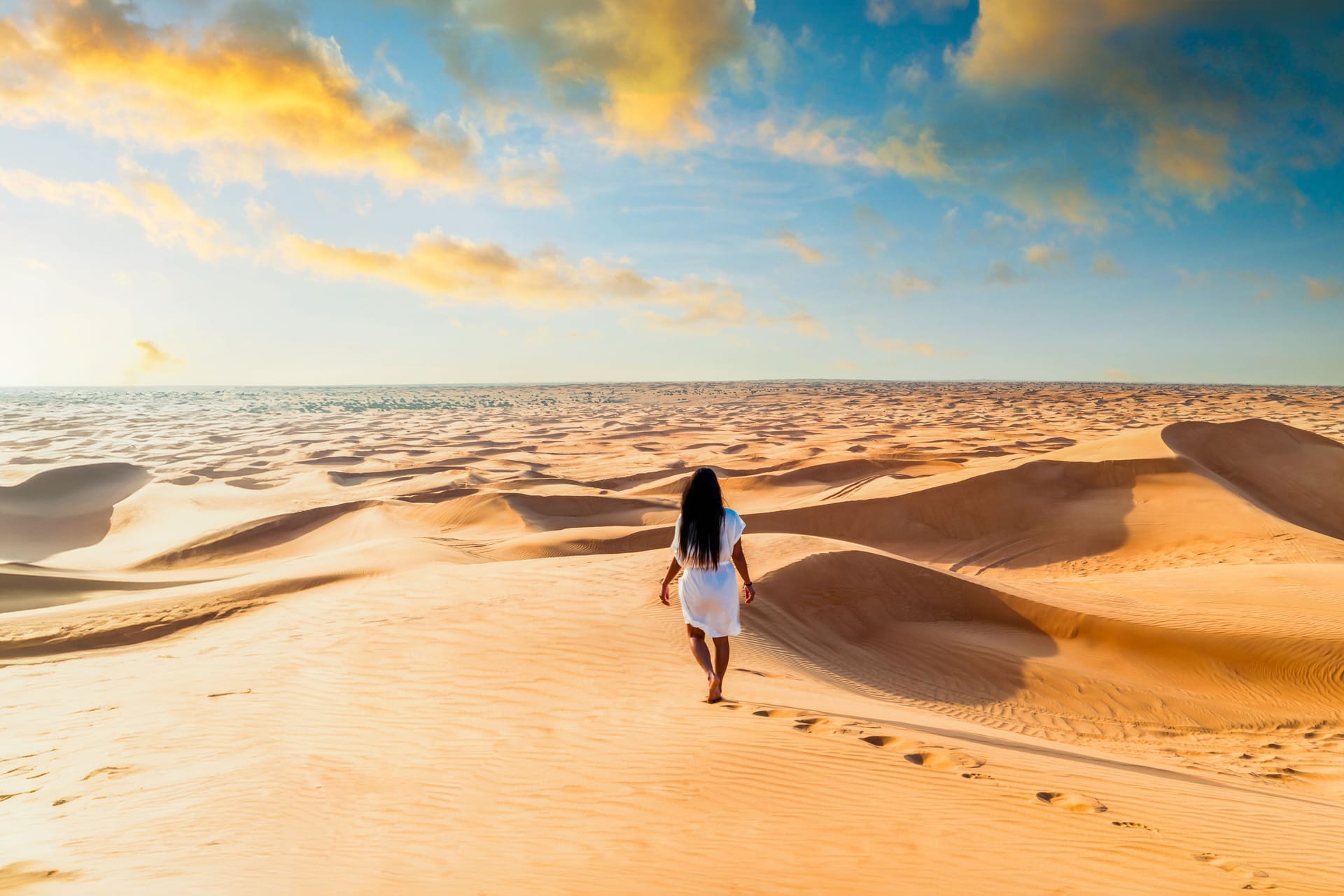 Eine Frau in den Sanddünen der Wüste in Dubai (Symbolbild) Für 23 Mitarbeiter zweier niederbayerischer Friseursalons geht es in den Urlaub.