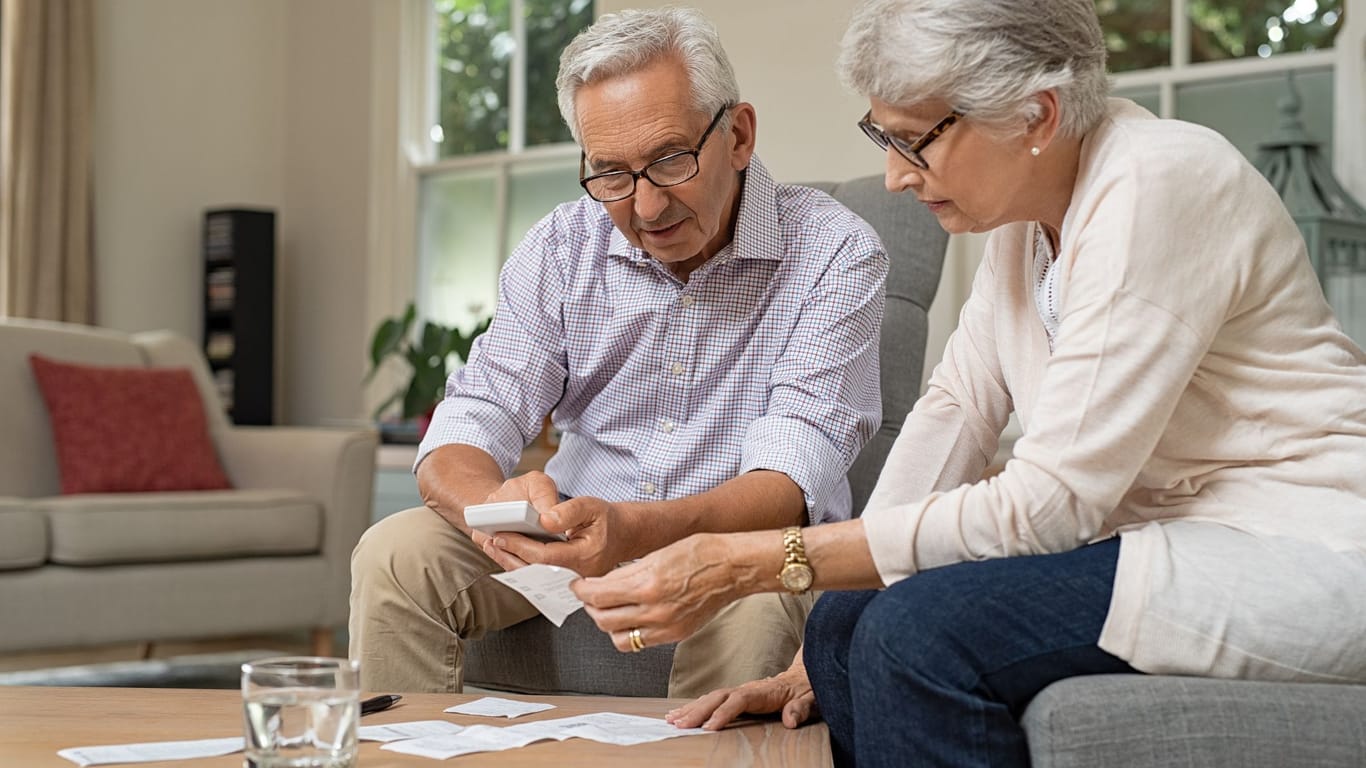 Rentnerpaar prüft seine Finanzen (Symbolbild): Sowohl Renten als auch Pensionen werden nachträglich besteuert.