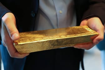 Ein Mann hält einen Goldbarren in der Hand (Symbolbild): Mit dem Wortquiz lässt sich echtes Gold gewinnen.