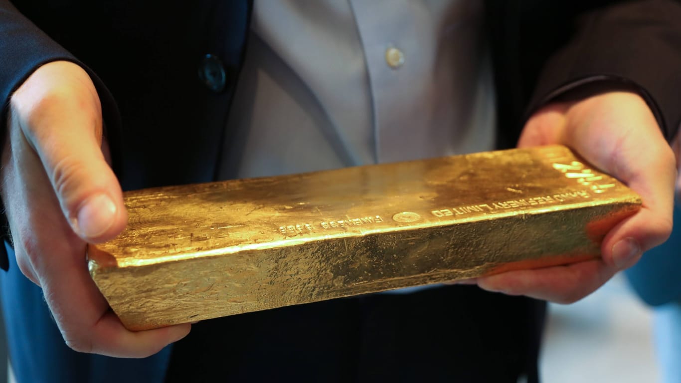 Ein Mann hält einen Goldbarren in der Hand (Symbolbild): Mit dem Wortquiz lässt sich echtes Gold gewinnen.