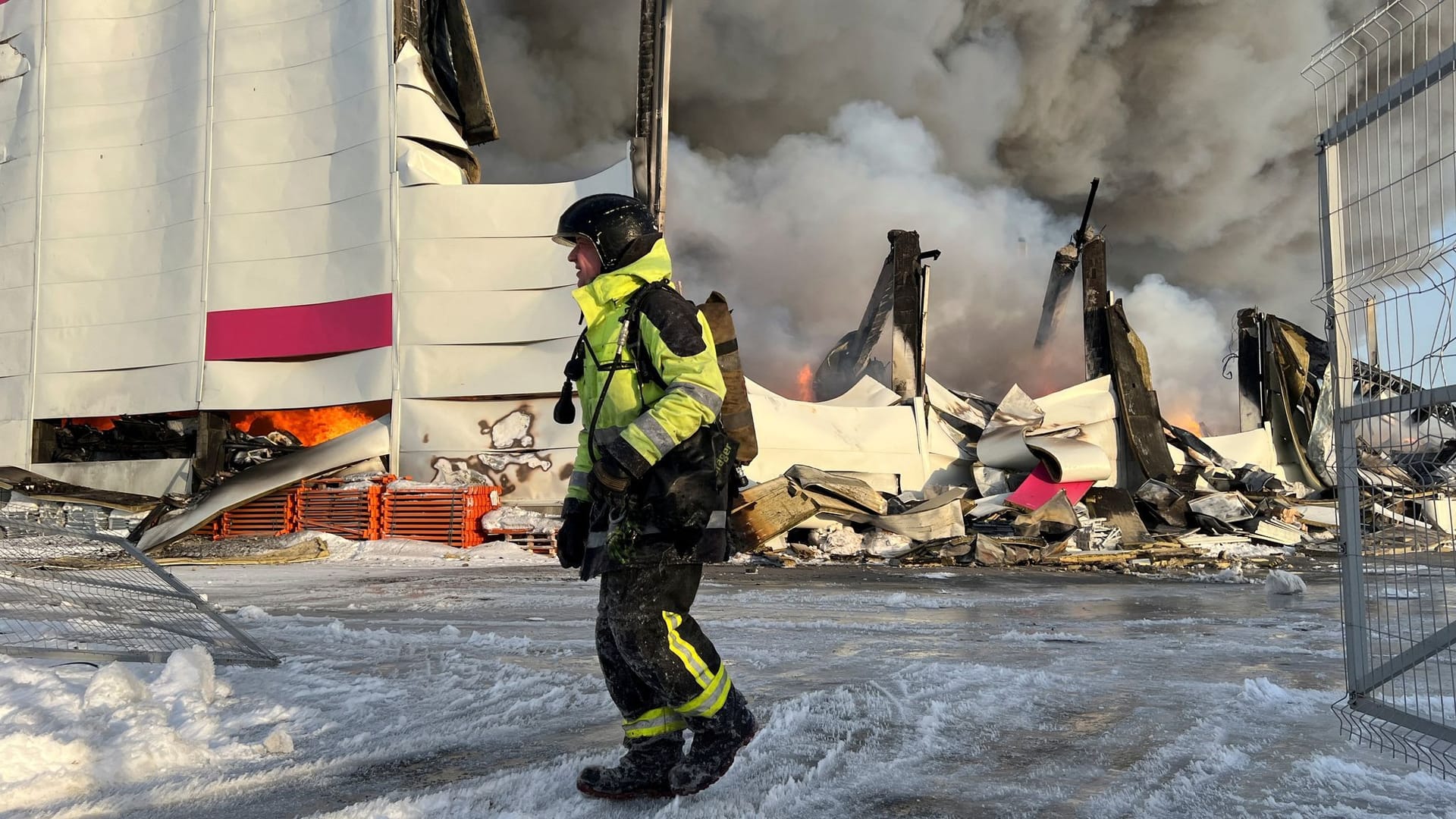 Feuerwehrmann vor dem abbrennenden Lagerhaus des Wildberriesversandhandels in St. Petersburg