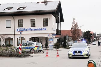 Die Polizei steht nach dem Geldtransporterüberfall vor der Raiffeisenbank in Großkarolinenfeld.