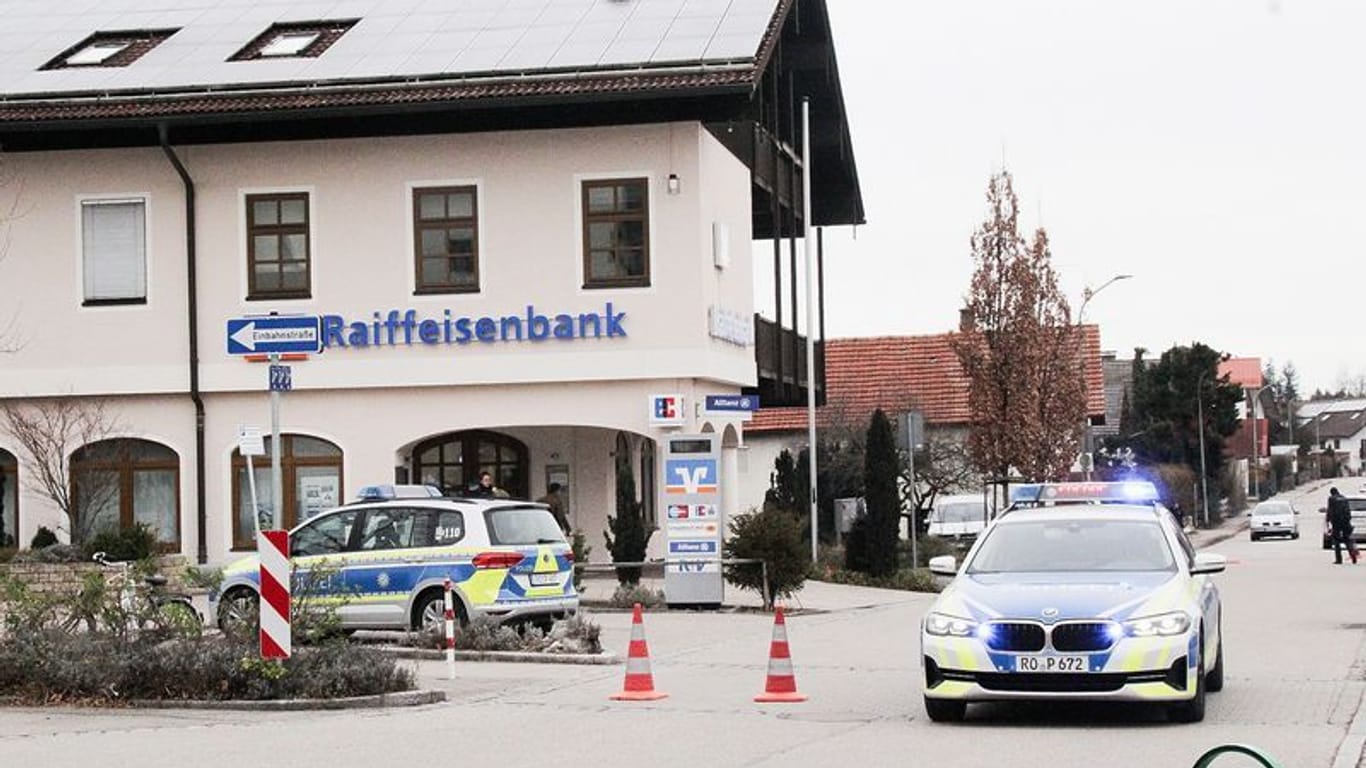 Die Polizei steht nach dem Geldtransporterüberfall vor der Raiffeisenbank in Großkarolinenfeld.