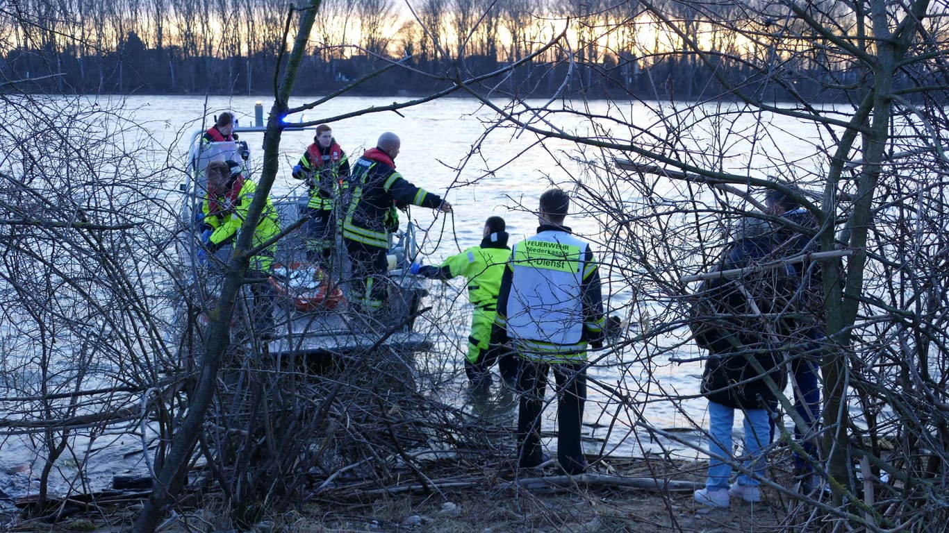 Einsatzkräfte der Feuerwehr am Rheinufer: Treibholzsammler entdeckten hier eine Wasserleiche.
