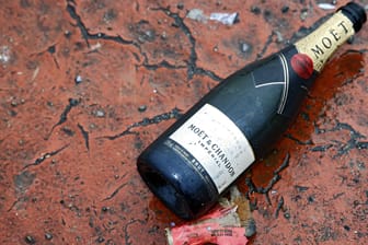 Champagner-Flasche auf dem Boden (Symbolbild): Zwar ging die Zahl der verkauften Flaschen zurück, lag aber trotzdem noch deutlich über dem Rekordtief im Jahr 2020.