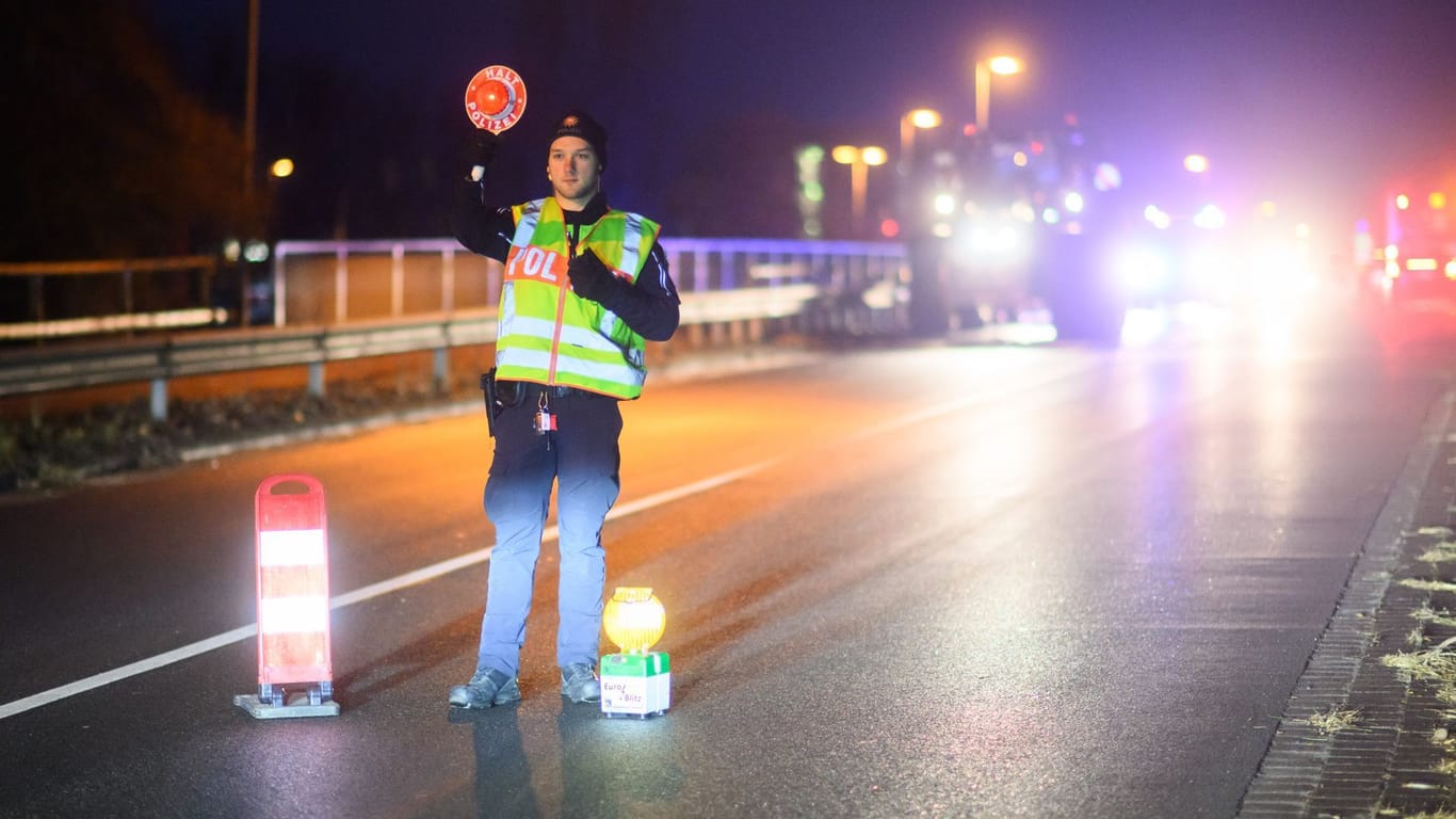 Ein Polizist regelt während einer Protestaktion von Bauern den Verkehr an einer Brücke über der Autobahn A2 bei Garbsen in der Region Hannover.