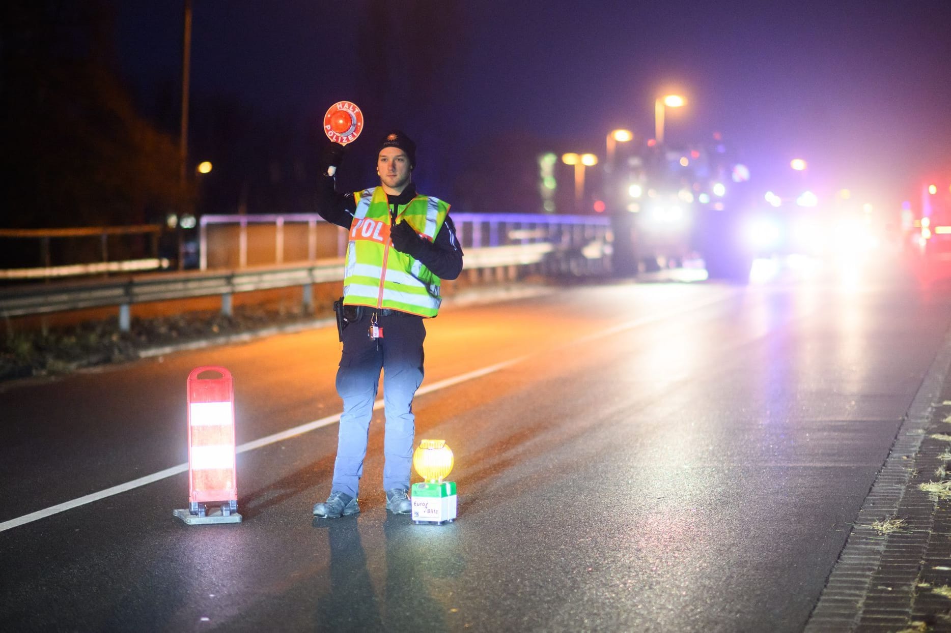 Ein Polizist regelt während einer Protestaktion von Bauern den Verkehr an einer Brücke über der Autobahn A2 bei Garbsen in der Region Hannover.