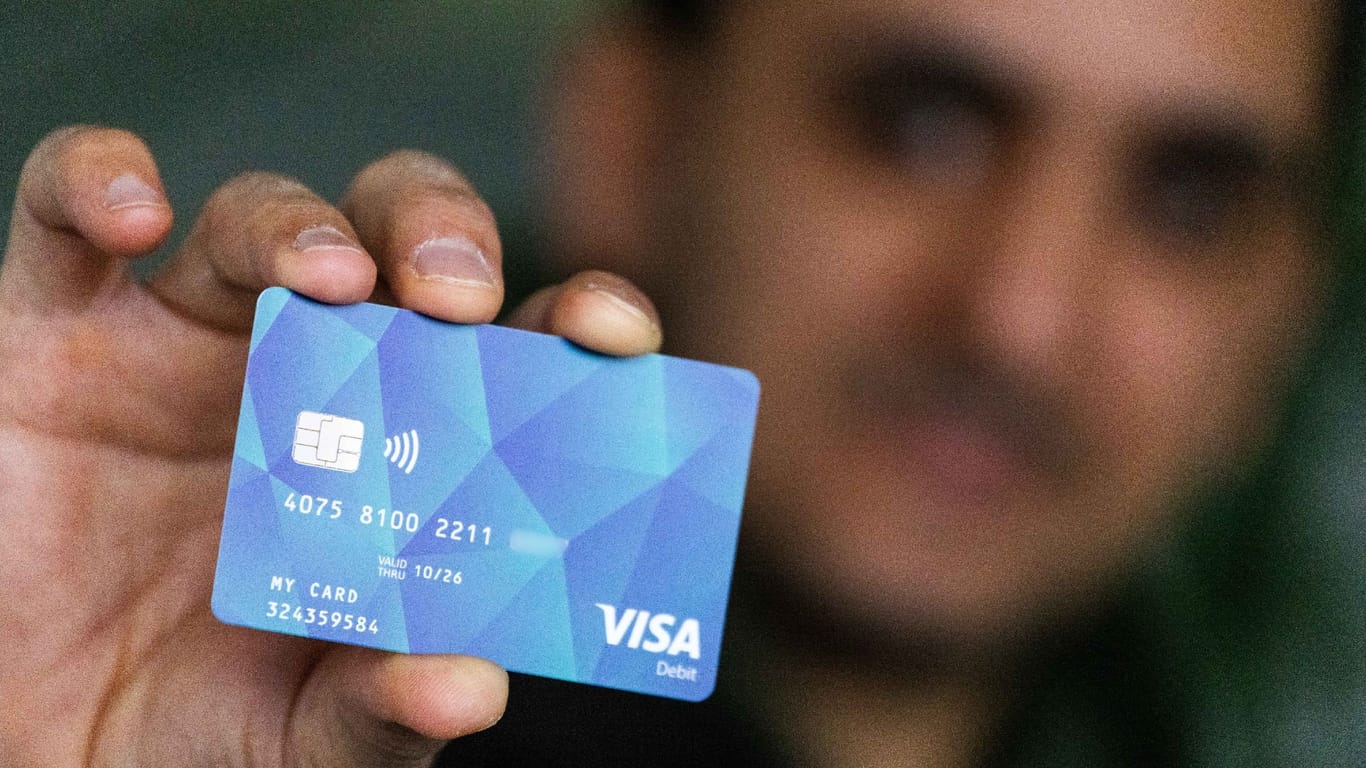 Ein Flüchtling hält eine Bezahlkarte in der Hand: Zusammen mit Sozialkürzungen für Asylbewerber sollen die Karten dafür sorgen, dass Deutschland unattraktiver für Flüchtlinge wird.