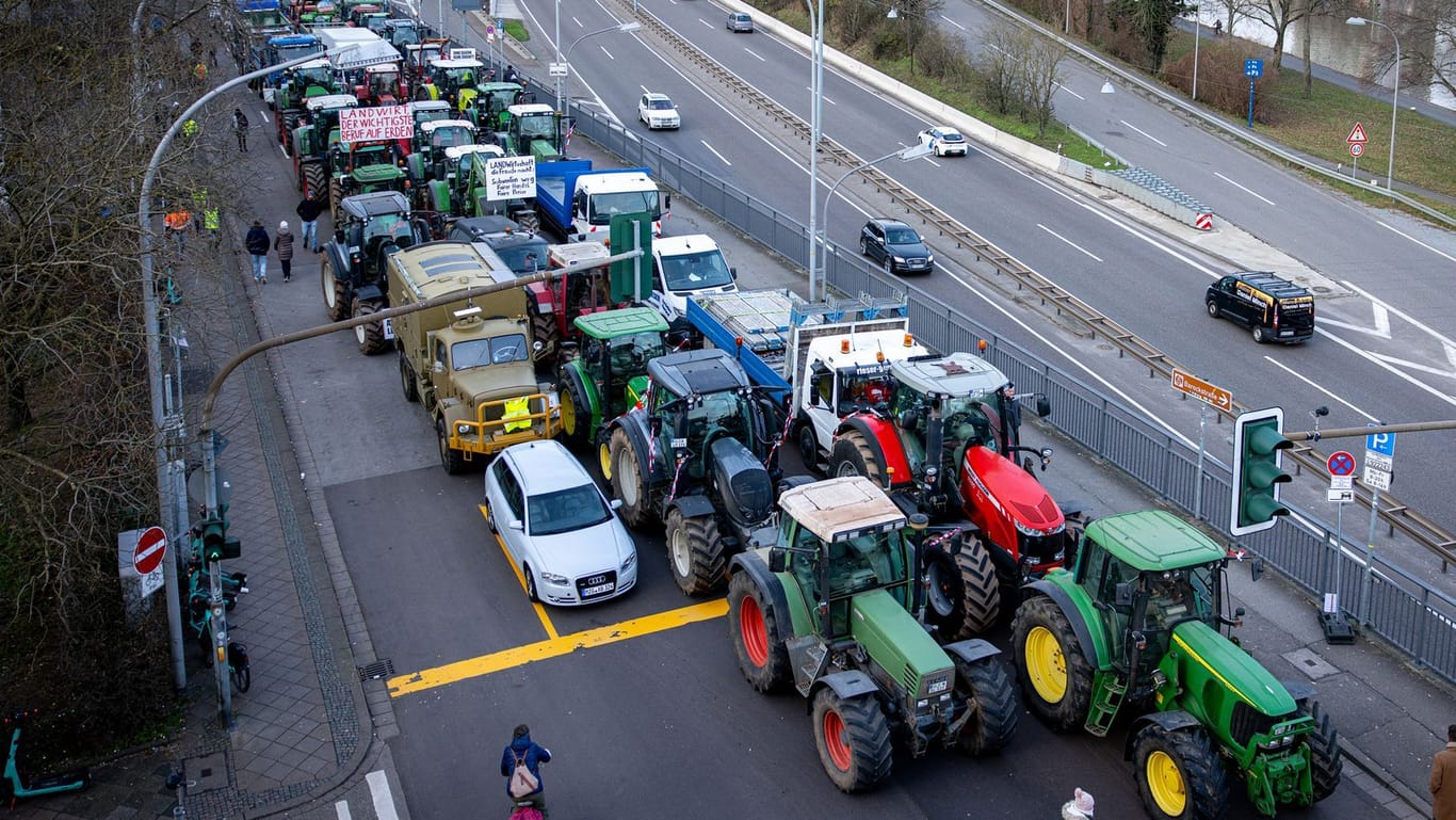 Traktoren stehen am Rande der Bauernproteste auf einer Straße in Saarbrücken (Archivbild): Am Mittwoch könnte es deutschlandweit zum Verkehrschaos kommen.