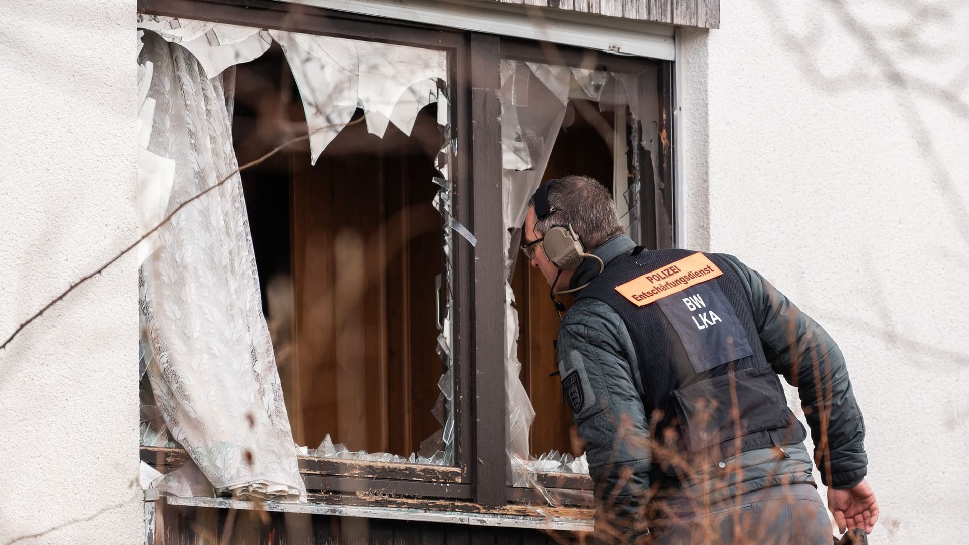 Ein Beamter des Entschärfungsdienstes der Polizei schaut durch ein eingeschlagenes Fenster einer Doppelhaushälfte: Weil eine Zwangsräumung zu eskalieren drohte, war die Polizei am Dienstag mit einem Großaufgebot im Schwarzwald-Baar-Kreis im Einsatz.