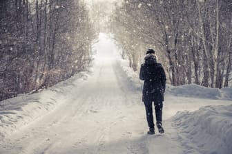 Jemand geht in einer winterlichen Landschaft spazieren