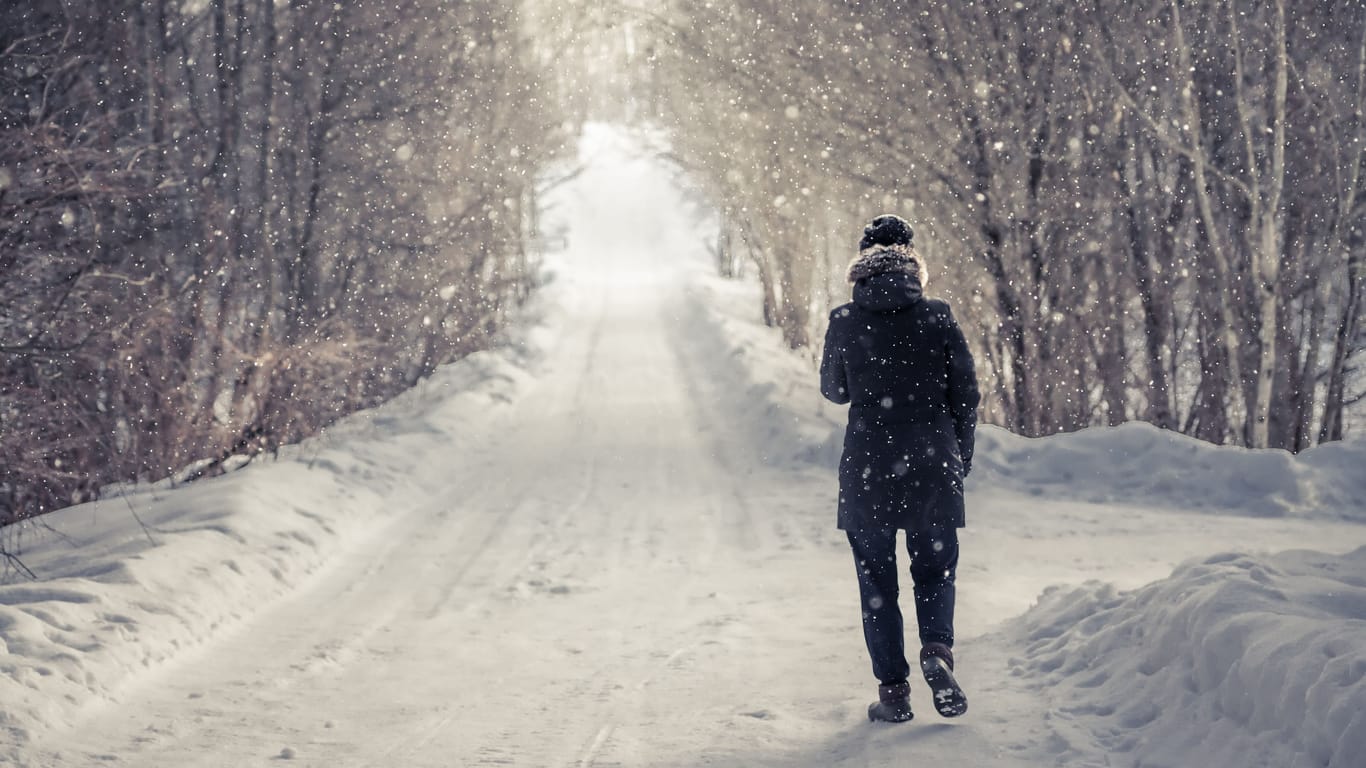 Jemand geht in einer winterlichen Landschaft spazieren