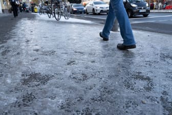 Ein glatte Eisfläche auf einem Bürgersteig in Berlin im Dezember 2023 (Archivfoto): Auch aktuell haben Kliniken wegen Brüchen wieder viel zu tun.