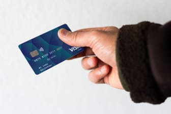Eine Person hält eine Debitkarte in der Hand (Symbolfoto): Bund und Länder hatten sich im November auf die Einführung von Bezahlkarten für Geflüchtete geeinigt.
