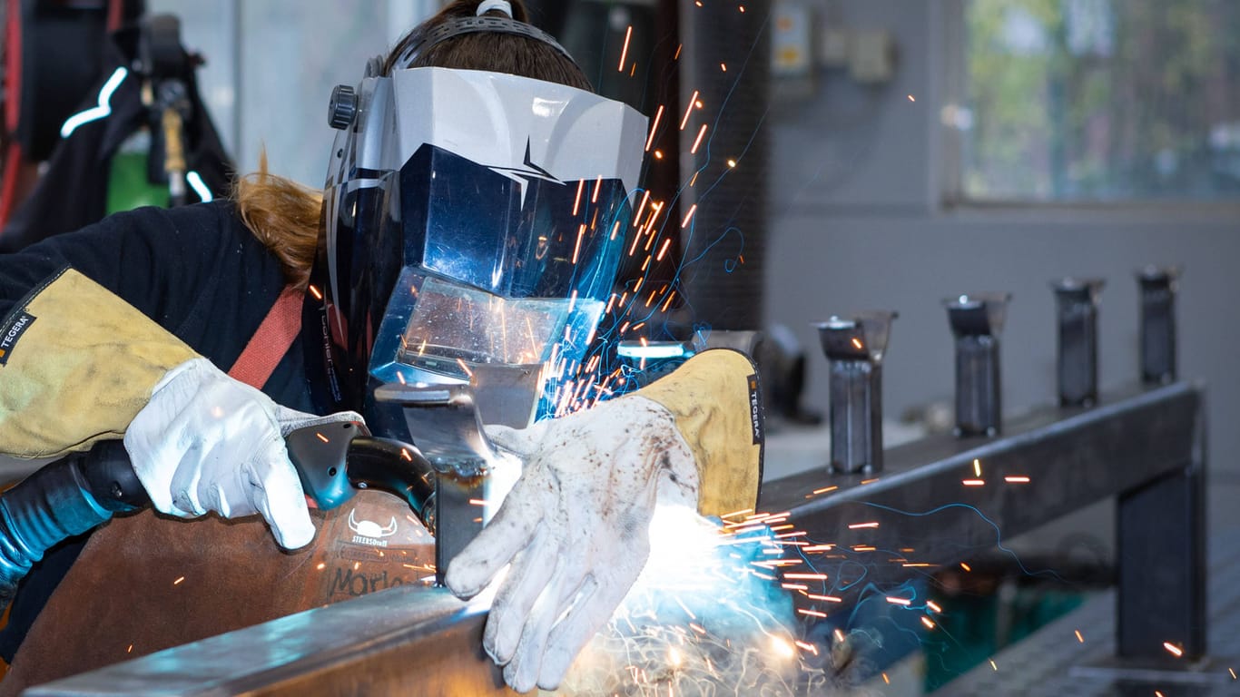 Eine Person arbeitet in einem Betrieb für Metallverarbeitung mit einem Schweißgerät (Symbolbild):