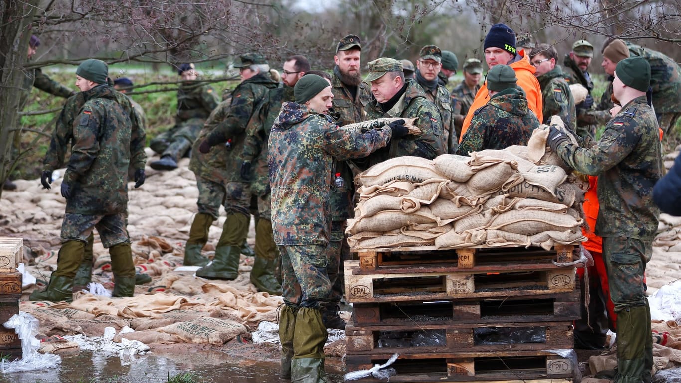 Oberröblingen: Soldatinnen und Soldaten der Bundeswehr sichern einen Deich an der Helme mit Sandsäcken.