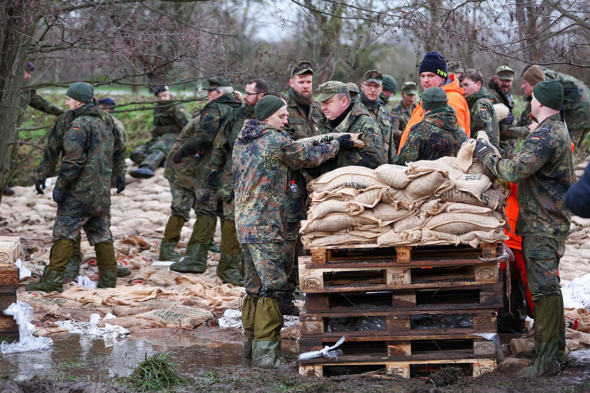 Oberröblingen: Soldatinnen und Soldaten der Bundeswehr sichern einen Deich an der Helme mit Sandsäcken.