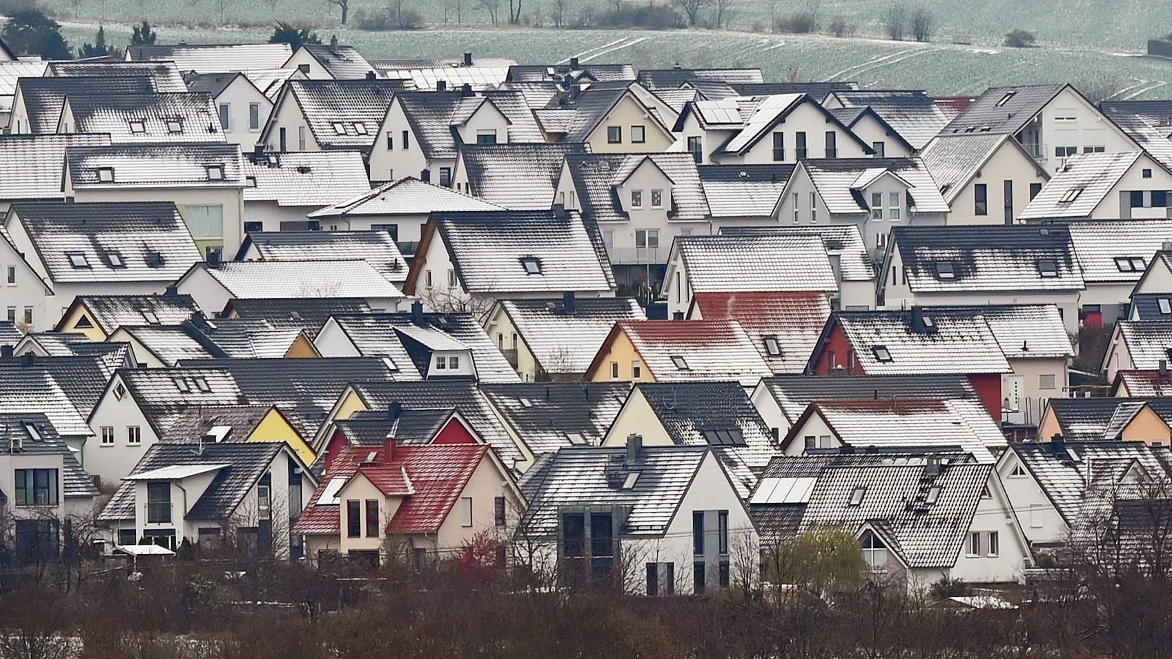 Verschneite Einfamilienhäuser (Symbolbild): Wer etwas an seinem Eigentum geändert hat, muss das dem Finanzamt mitteilen.