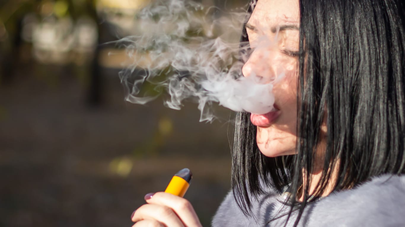 Eine Frau raucht eine E-Zigarette (Archivbild): Die Charité warnt Jugendliche vor der Nutzung von Vapes.