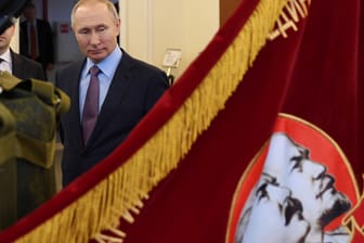 Wladimir Putin vor einer Fahne mit den sowjetischen Führern Lenin und Stalin: Russlands Präsident betrachtet Lenin als Verräter.