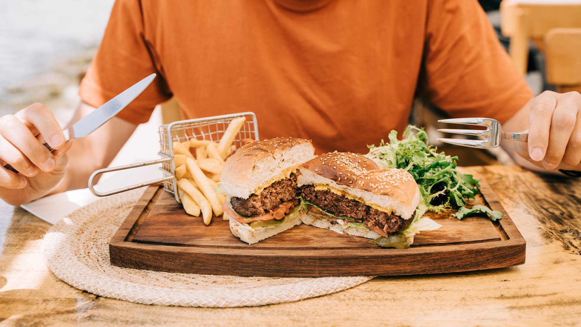 Ein Mann sitzt vor einem Burger-Menü (Symbolbild): Die schlechten Bewertungen stoßen dem Restaurant übel auf. Ein Mann sitzt vor einem Burger-Menü (Symbolbild): Die schlechten Bewertungen stoßen dem Restaurant übel auf.