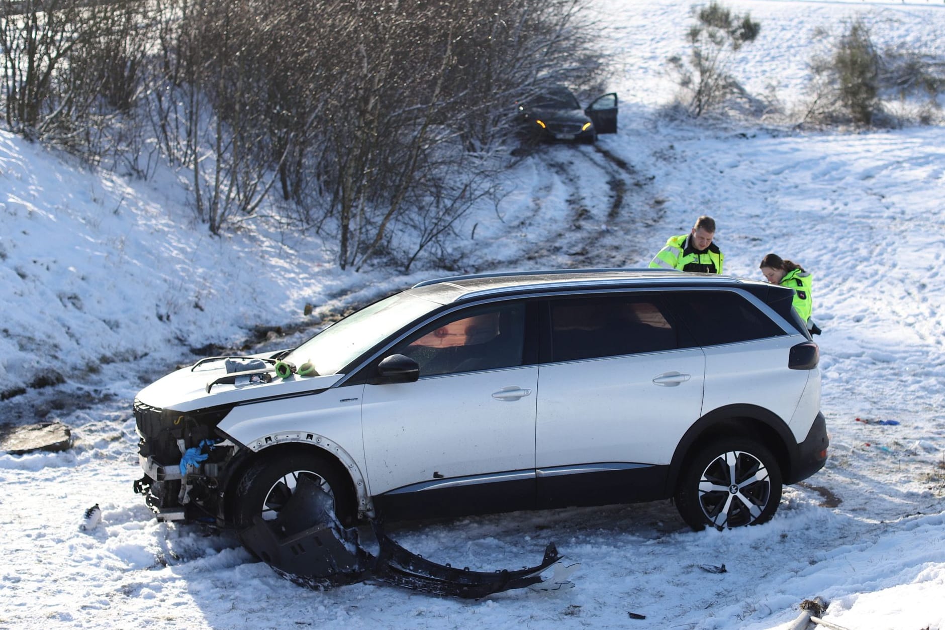 Zwei beschädigte Autos stehen abseits der Autobahn auf einer Wiese: Der weiße SUV soll die Gruppe Ersthelfer erfasst haben.