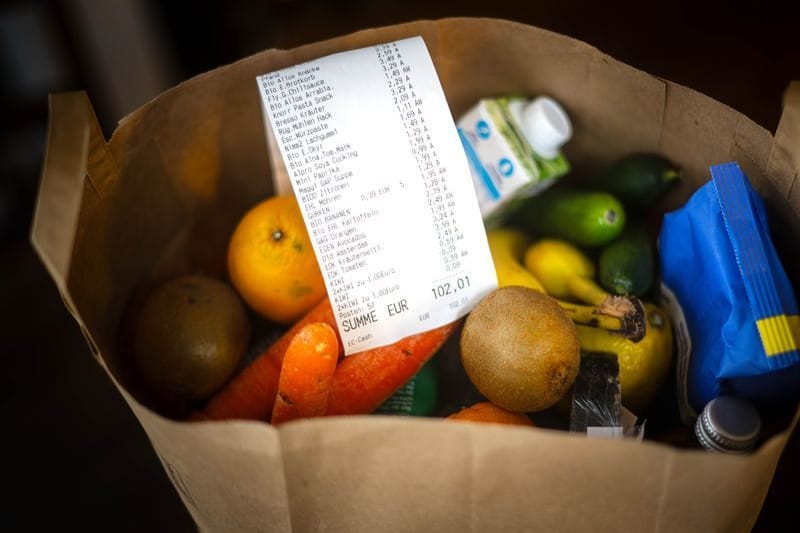 Ein Kassenbon liegt auf den Lebensmitteln in einer Einkaufstüte (Symbolbild): Die Inflation in NRW ist gestiegen.